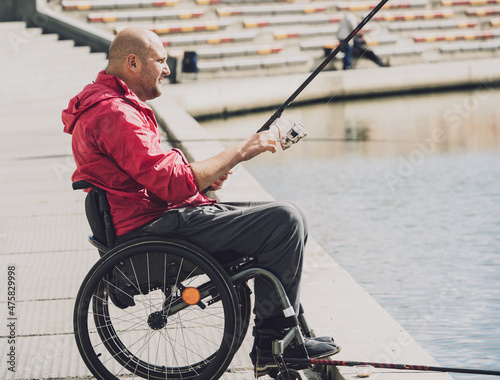 Person with a physical disability who uses wheelchair fishing from fishing pier.