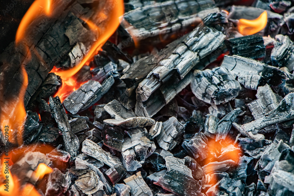 Glowing embers in hot red color, abstract background. The hot embers of burning wood log fire. Firewood burning on grill. Texture fire bonfire embers. Glowing embers in hot red color, abstract background. The hot embers of burning wood log fire. Firewood burning on grill. Texture fire bonfire embers.