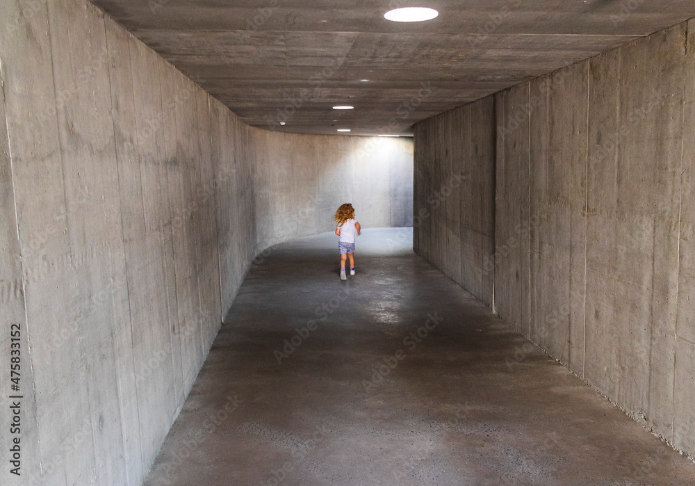 Shot of a little girl running trough the tunnel. Concept Shot of a little girl running trough the tunnel. Concept