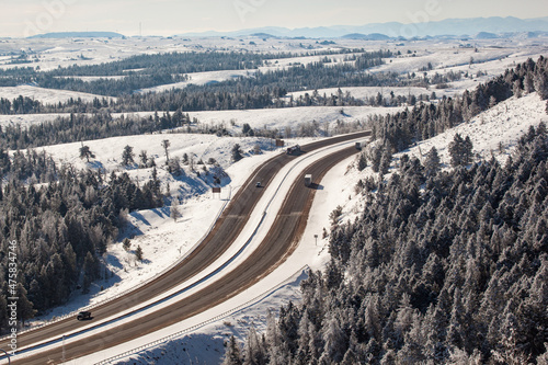 Aerial shot of winter roads lined with snow and alpine trees along I-80 in southern Wyoming photo