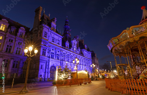 Parisian City Hall decorated with Christmas trees for winter holidays at night. Winter travel and tourist attractions in Europe concept. Celebration background.