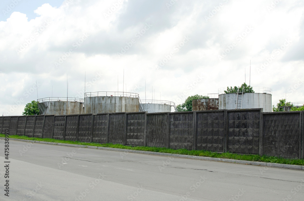 Oil storage tanks behind the concrete fence