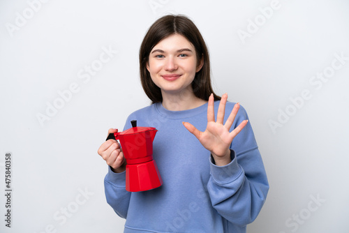 Young Russian woman holding coffee pot isolated on white background counting five with fingers