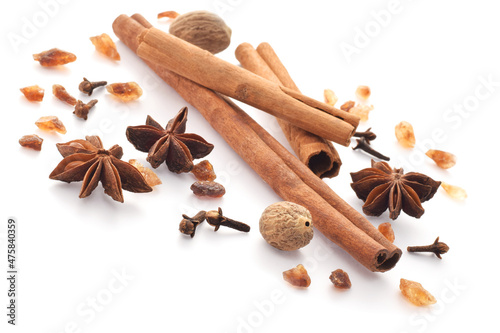 Spicy cinnamon sticks, anise stars, unrefined sugar crystalls isolated on white photo