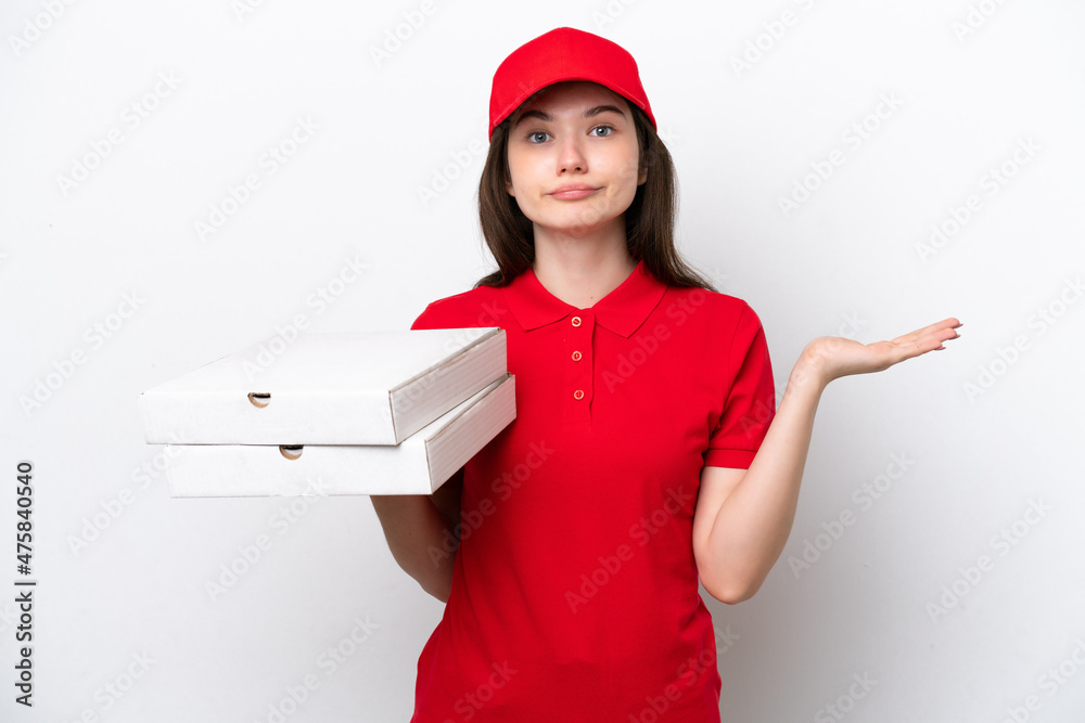 Young Russian pizza delivery picking up pizza boxes isolated on white background having doubts while raising hands Young Russian pizza delivery picking up pizza boxes isolated on white background having doubts while raising hands