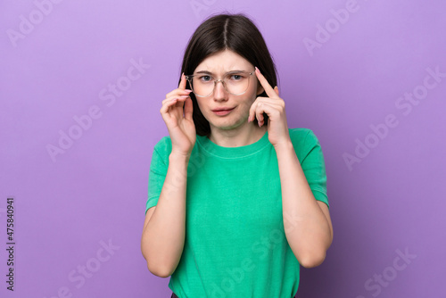 Young pretty Russian woman isolated on purple background With glasses and frustrated expression