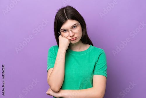 Young pretty Russian woman isolated on purple background With glasses and with sad expression