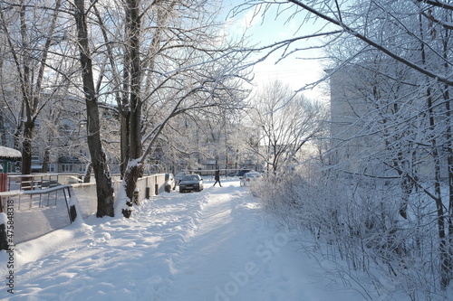 зима в городе снег дорога деревья солнце небо пешеход машина в снегу забор россия