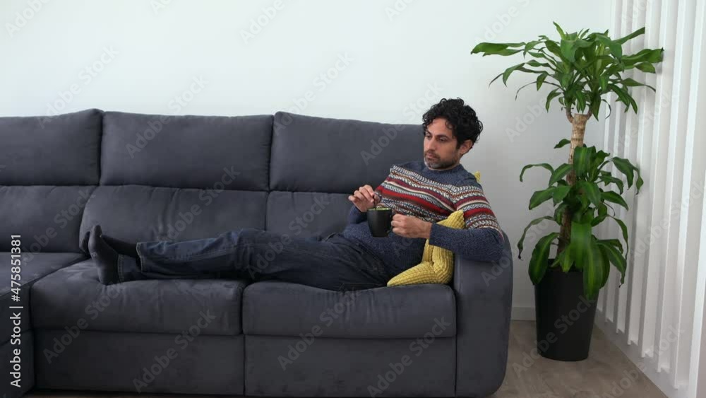 Caucasian man drinking morning expresso coffee while feeling exhausted and lying down on couch home. Handsome male model feels tired after work and having a cafe. Caucasian man drinking morning expresso coffee while feeling exhausted and lying down on couch home. Handsome male model feels tired after work and having a cafe.
