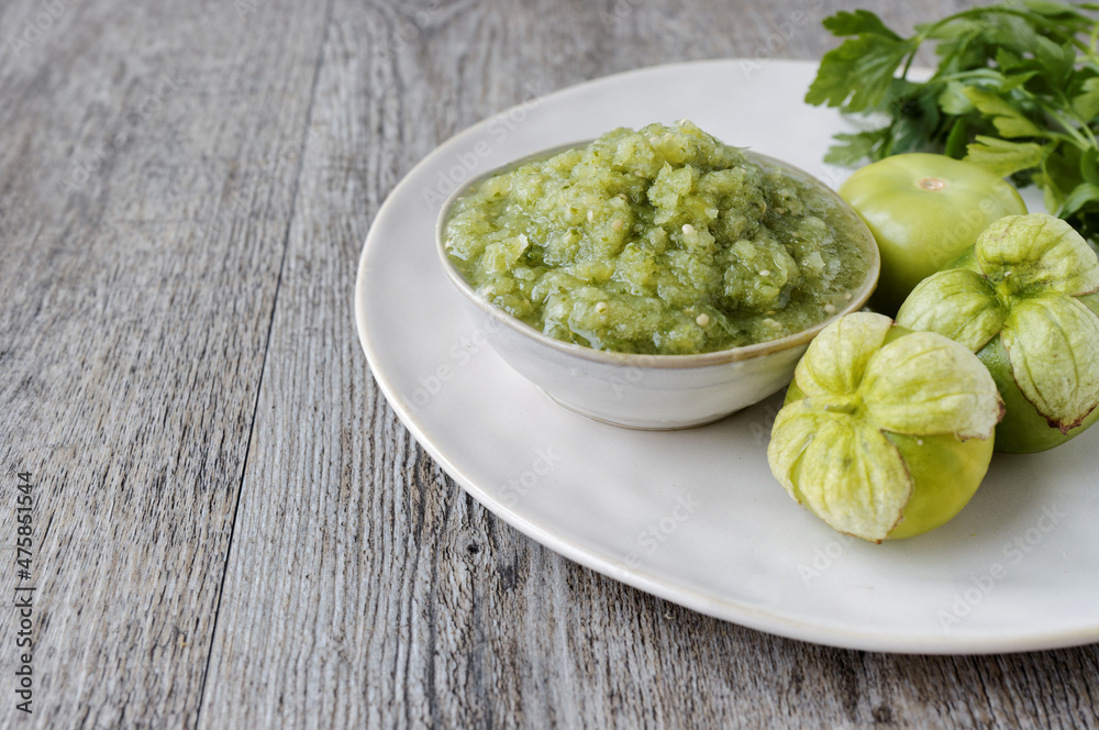 Fresh tomatillo green salsa (salsa verde cruda) in a bowl. Typical Mexican cuisine. Fresh tomatillo green salsa (salsa verde cruda) in a bowl. Typical Mexican cuisine.