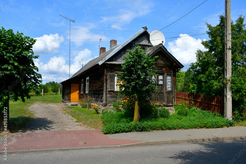 A view of an old wooden hut or shack made out of wood standing in the middle of a dense orchard or forest, seen during a sunny summer day during a hike on a Polish countryside A view of an old wooden hut or shack made out of wood standing in the middle of a dense orchard or forest, seen during a sunny summer day during a hike on a Polish countryside