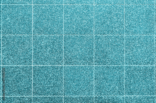 Light blue tile of the original shape as a background for the design. The pattern and texture of the decorative material.