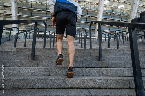 Adult sportsman running on steps, training outdoors