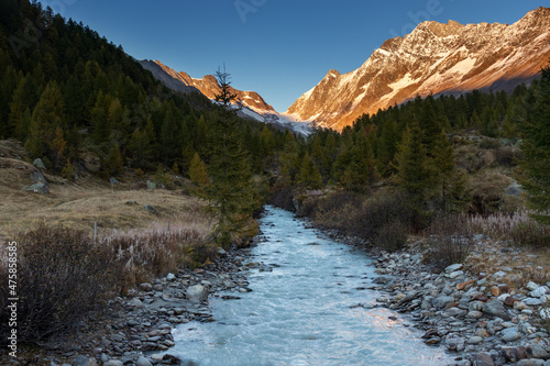 River flowing through beautiful autumn landscape at sunset. photo