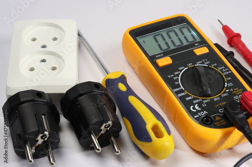 Multimeter, screwdriver, socket for two connections, electrical plugs.