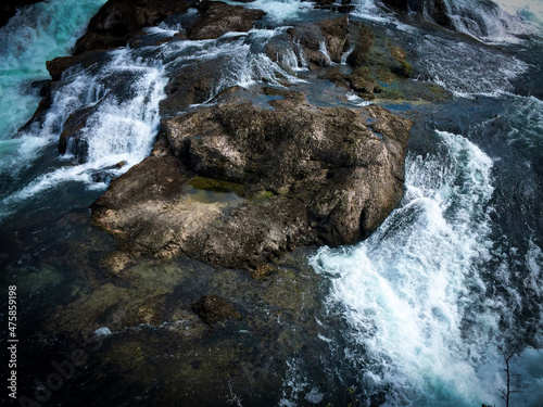Closeup shot of water flowing downstream on a rocky river