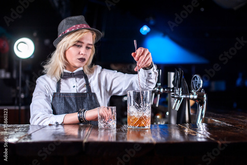 Girl barman creates a cocktail on the alehouse photo