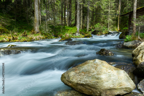 The 'Riesachbach' mountain creek flowing downhill through forest landscape with long exposure effect
