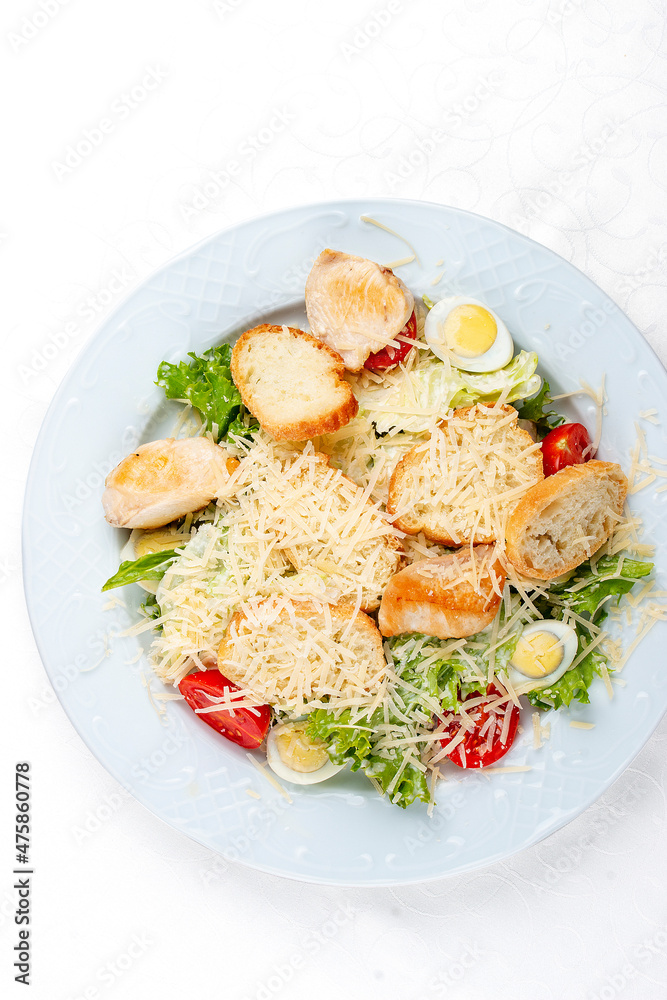 Caesar salad with chicken, egg and fresh vegetables. Isolated on a white background Caesar salad with chicken, egg and fresh vegetables. Isolated on a white background