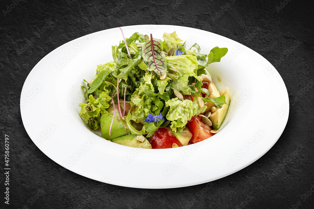 Salad with avocado and pine nuts. Isolated on a black background. Salad with avocado and pine nuts. Isolated on a black background.