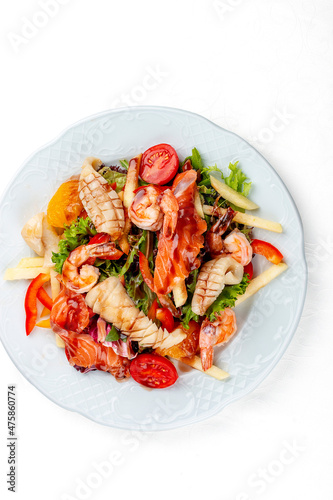 Salad Di Mare .Salad with shrimp, salmon and squid, orange and sweet pepper. Isolated on a white background