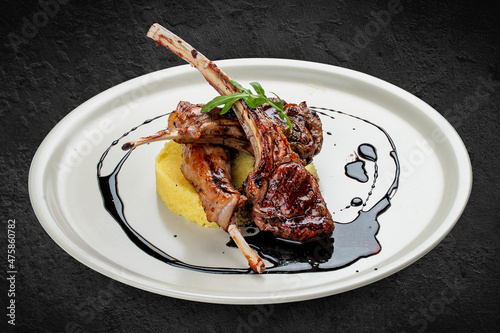 Rack of lamb with couscous with cherry sauce. Isolated on a black background