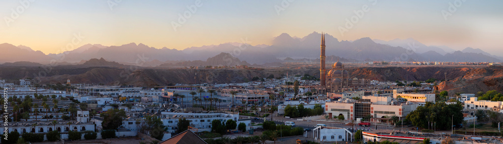Panoramic top view of Al Sahab mosque and old town at sunset, banner. Silhouettes of people in shopping area with souvenirs in shine of night lights, Sharm El Sheikh, Egypt. High quality photo