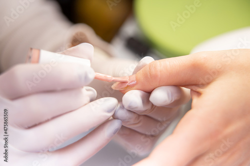 applied varnish to a treated nail. Varnishing in a beauty studio close-up