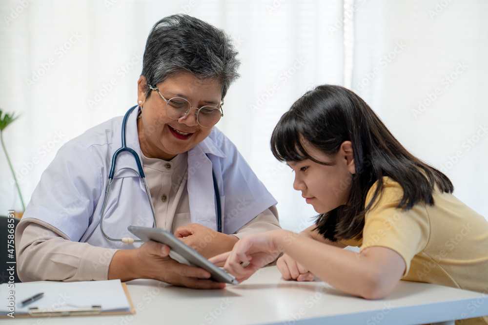 The doctor gives the young patient the results of the examination with a computer tablet. The doctor gives the young patient the results of the examination with a computer tablet.