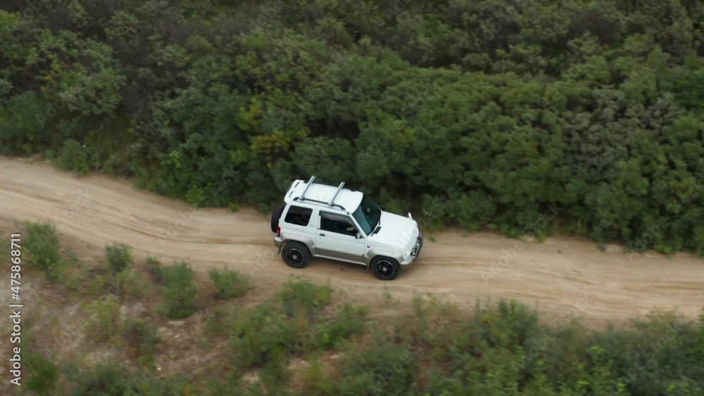 Aerial view of a car driving on sand