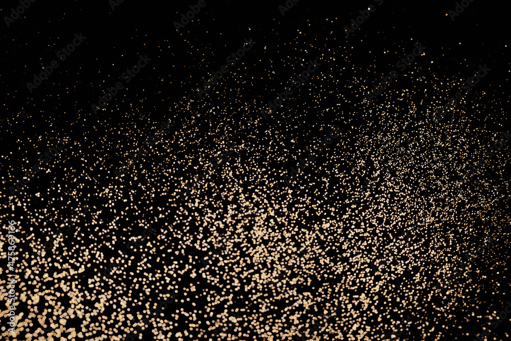 Black festive background of golden glitter lights. Holiday backdrop, selective focus Black festive background of golden glitter lights. Holiday backdrop, selective focus