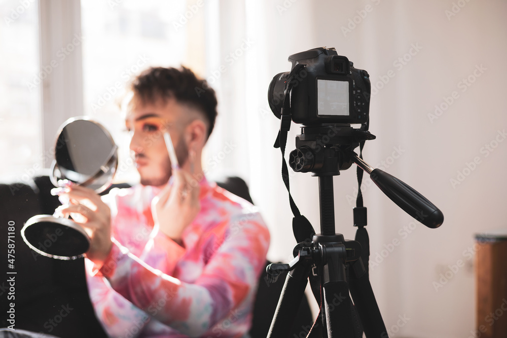 A gay man putting on makeup in live video streaming on social media with a  video camera. lifestyle and fashion concept. foto de Stock | Adobe Stock