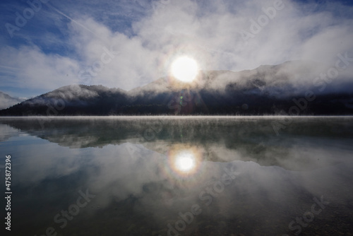 Alpiner Stausee Sylvensteinspeicher im morgendlichen Nebel und Kondensstreifen an einem kalten Tag im Herbst  photo