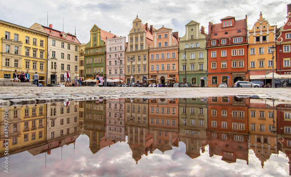 Fototapeta premium Wroclaw, Poland - due to the frequent rain, in Wroclaw you can easely find water pools, and use them to make nice shots. Here in particular the mirror effect in the Old Town