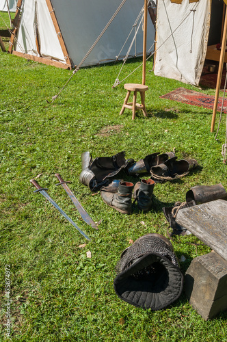 Blick auf ein nachgebautes mittelalterliches Zelt mit Vordach und Interieur. Sowie Waffen und Schutzkleidung photo