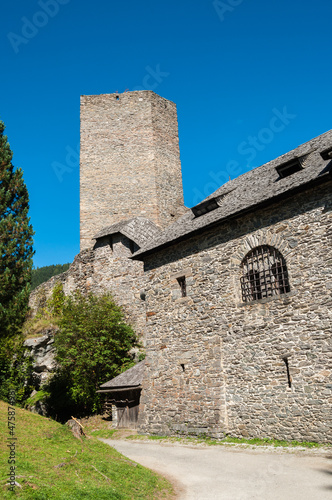 Detailaufnahme einer alten Burg mit Turm  vor strahlend blauem Himmel