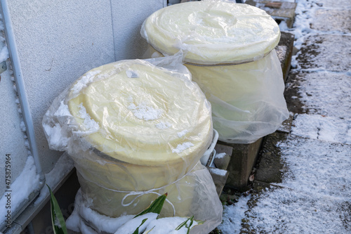 家の外の日陰に置かれた漬物桶 photo