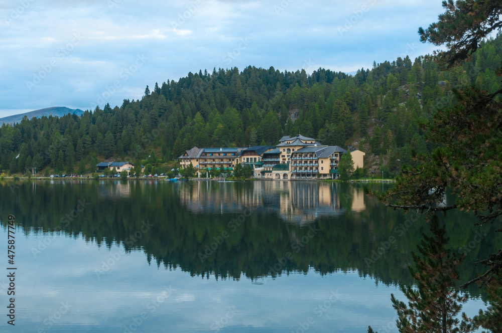 Obraz premium Romantischer Blick auf ein Hotel am Rand eines Sees mit den Bergen im Hintergrund