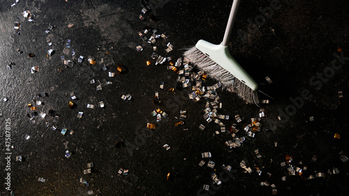Bild auf Leinwand Cleaning broom and golden confetti on a black background