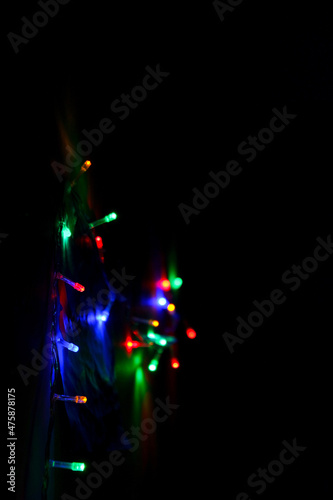 Christmas and New Years concept - defocused abstract multicolored bokeh lights on dark background. Blue  purple  green  orange colors. 