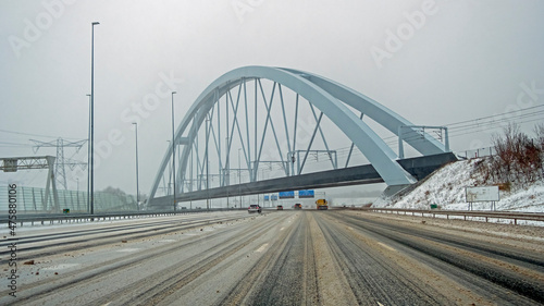 Driving on the highway A1 near Amsterdam at the Zandhazen bridge during a snow storm in the Netherlands