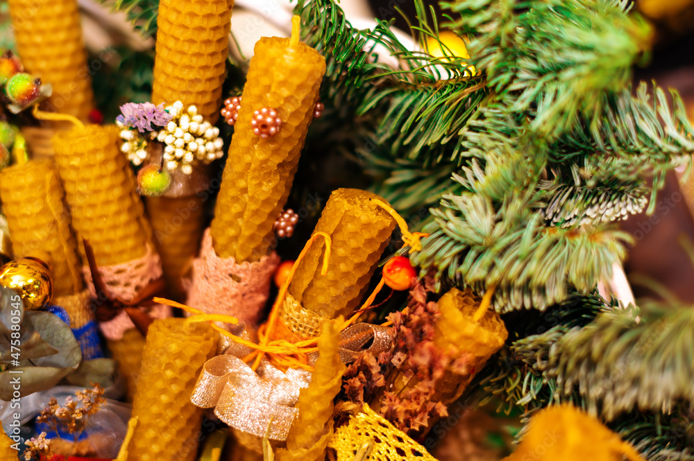 Beeswax candles decorated in Christmas style and a twig tree. Design for the new year.
