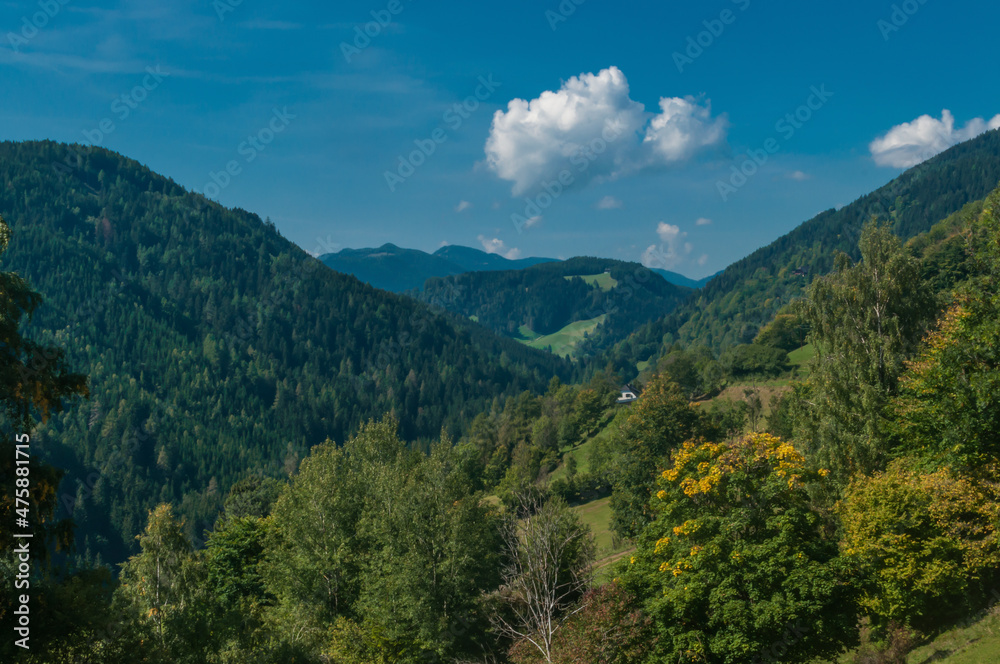 Blick in ein Tal der Steiermark an einem sonnigen Herbsttag mit schönen Wolken