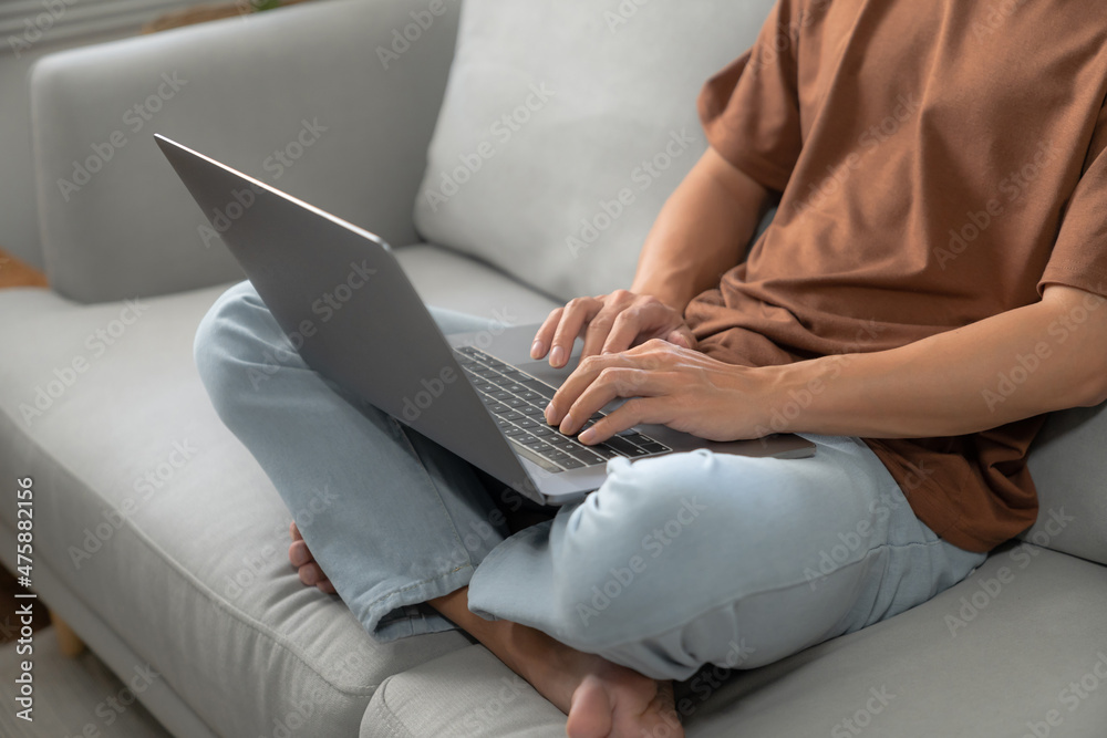Fototapeta premium Work at home young asian man working on laptop computer while sitting at home Morning lifestyle