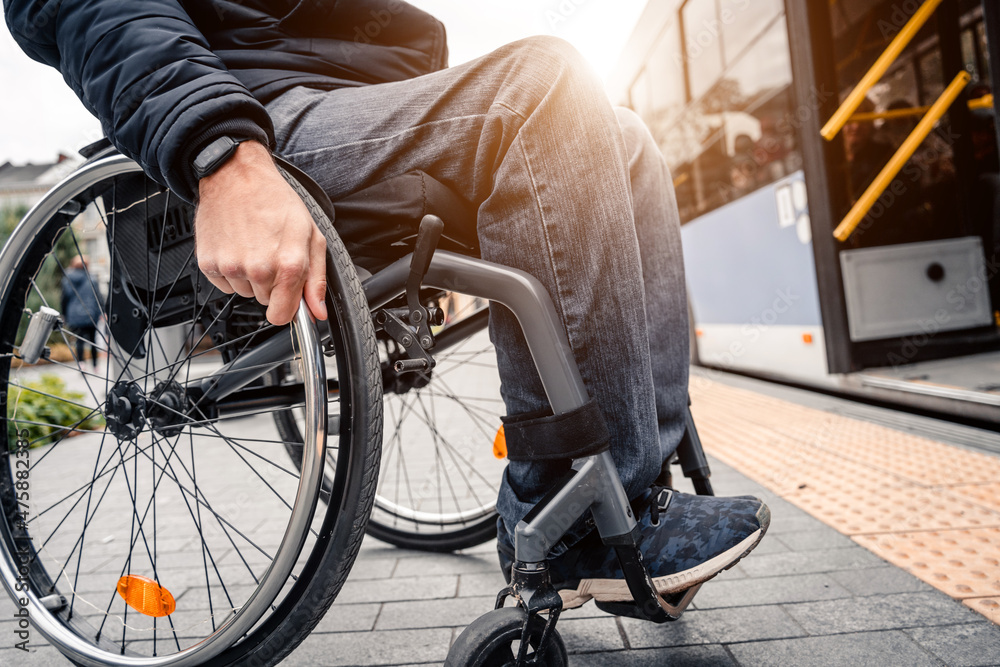 Obraz premium Person with a physical disability enters public transport with an accessible ramp.