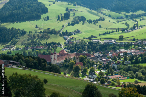 Blick auf einen Ort in der Steiermark, der in einem Tal liegt. Zentral ein Gebäude der Kirche