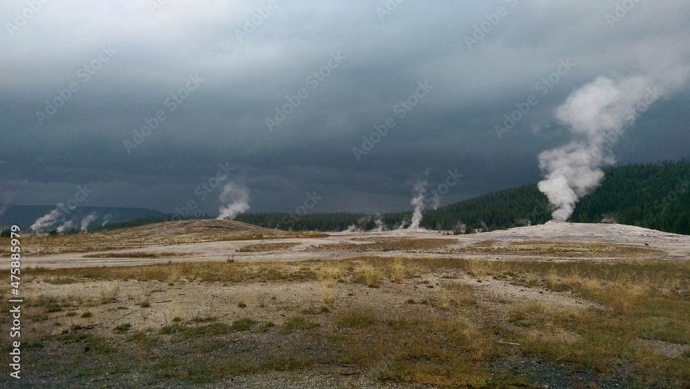 Old Faithful erupting under stormy skies, Yellowstone National Park, Wyoming