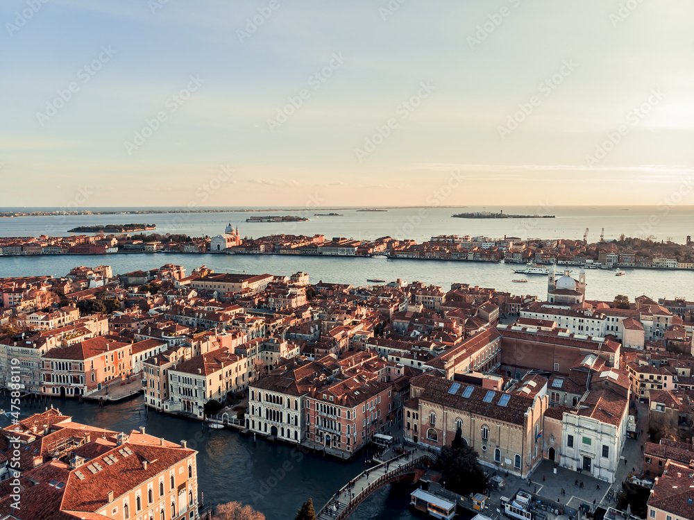 Aerial view of the busy bridge near Venice. A drone panorama of the city overlooking the canal of the Adriatic Sea in northern Italy. A shot of people walking across the bridge from a drone. Sunset