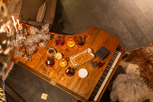 An interior with a grand piano as a server table. Holidays, wine and snacks. New year