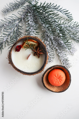 christmas background. handmade christmas candle made of natural soy wax in the shape of snowflake and tangerine